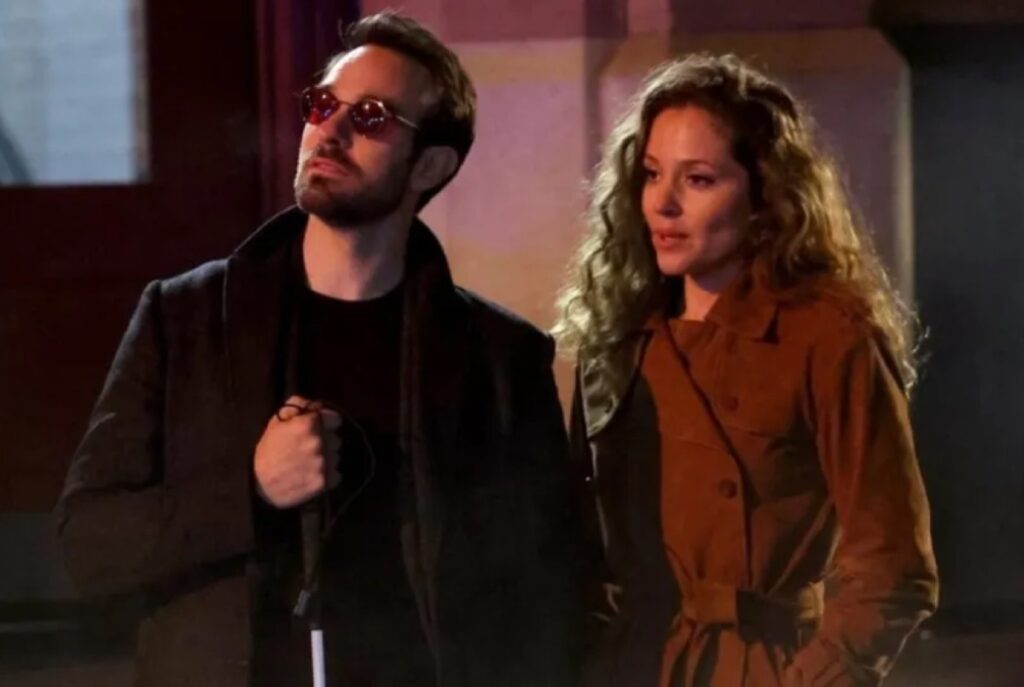 blind man arm in arm with a lovely brunette woman in a red coat