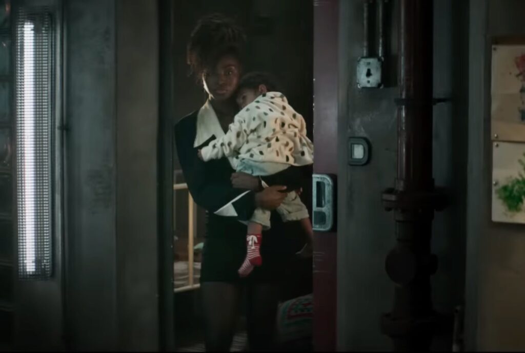 A woman holding her child standing in a doorway.