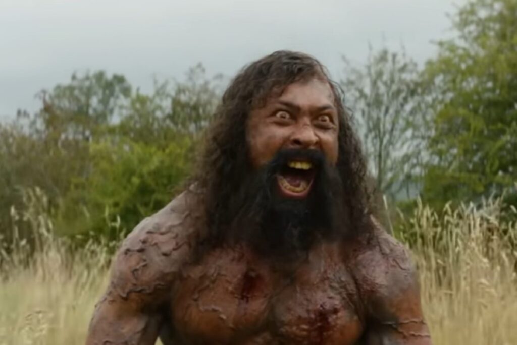 A wild-eyed zombie giving a war cry.